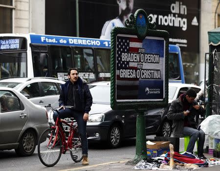 A man looks at a poster placed on an advertising board that reads "Yesterday, Braden or Peron - Today: Griesa or Cristina", in Buenos Aires July 29, 2014. REUTERS/Marcos Brindicci