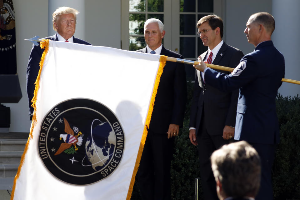 President Donald Trump watches with Vice President Mike Pence and Defense Secretary Mark Esper as the flag for U.S. space Command is unfurled as Trump announces the establishment of the U.S. Space Command in the Rose Garden of the White House in Washington, Thursday, Aug. 29, 2019. (AP Photo/Carolyn Kaster)