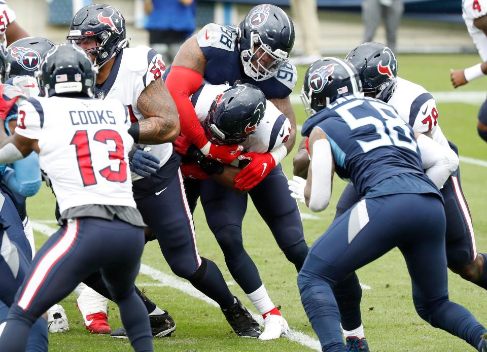 Tennessee Titans defensive tackle Jeffery Simmons (98) wraps up Houston Texans running back David Johnson on Oct. 18, 2020, in Nashville, Tennessee.