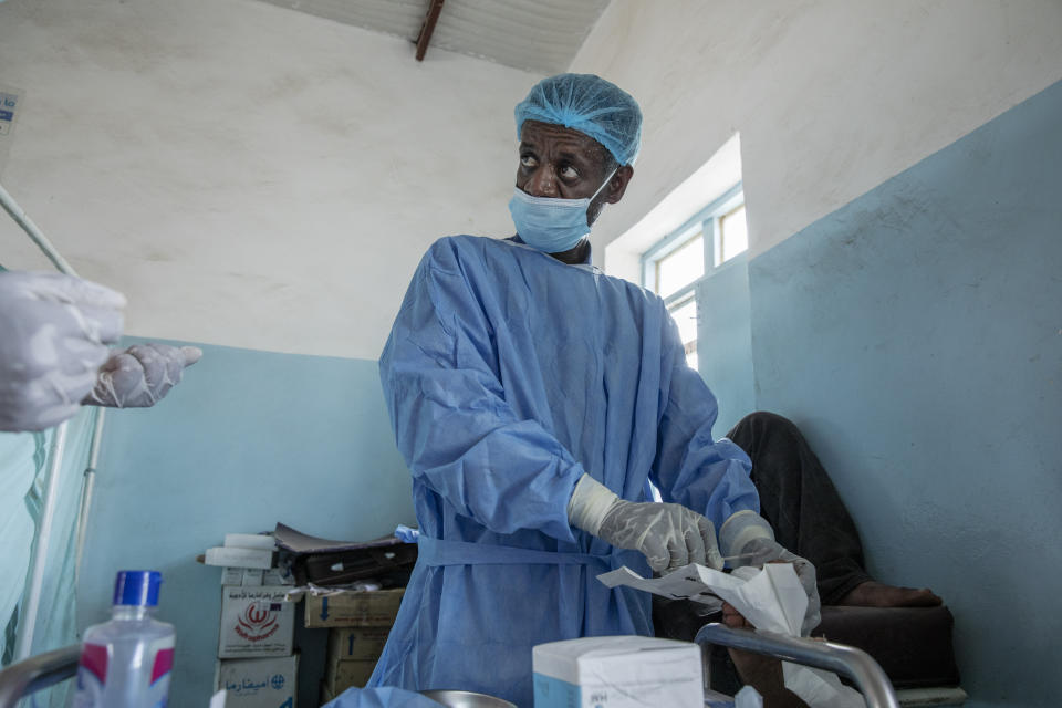 Surgeon and doctor-turned-refugee, Dr. Tewodros Tefera, performs surgery on a man's severely infected toe, inside the Sudanese Red Crescent clinic, in Hamdayet, eastern Sudan, near the border with Ethiopia, on March 22, 2021. (AP Photo/Nariman El-Mofty)