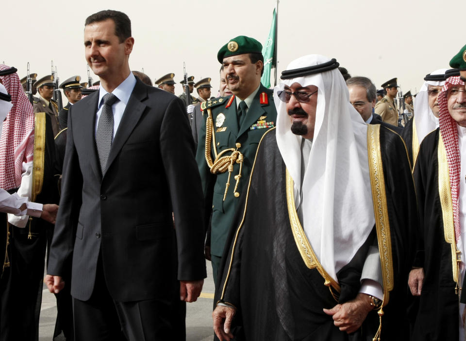 FILE - In this March 11, 2009 file photo, King Abdullah of Saudi Arabia, right, welcomes Syrian President Bashar Assad upon his arrival to attend the Arab Summit, in the Saudi capital Riyadh. Assad has survived years of war and millions of dollars in money and weapons aimed at toppling him. Now after nearly eight years of conflict, he is poised to be readmitted to the fold of Arab nations, a feat once deemed unthinkable as he brutally crushed a years-long uprising against his family’s rule. (AP Photo/Hassan Ammar, File)