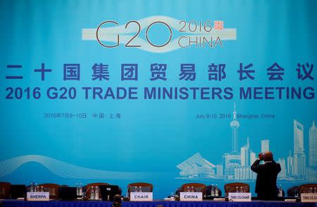 An attendee takes pictures before the opening ceremony of the 2016 G20 Trade Ministers Meeting in Shanghai, China July 9, 2016. REUTERS/Aly Song