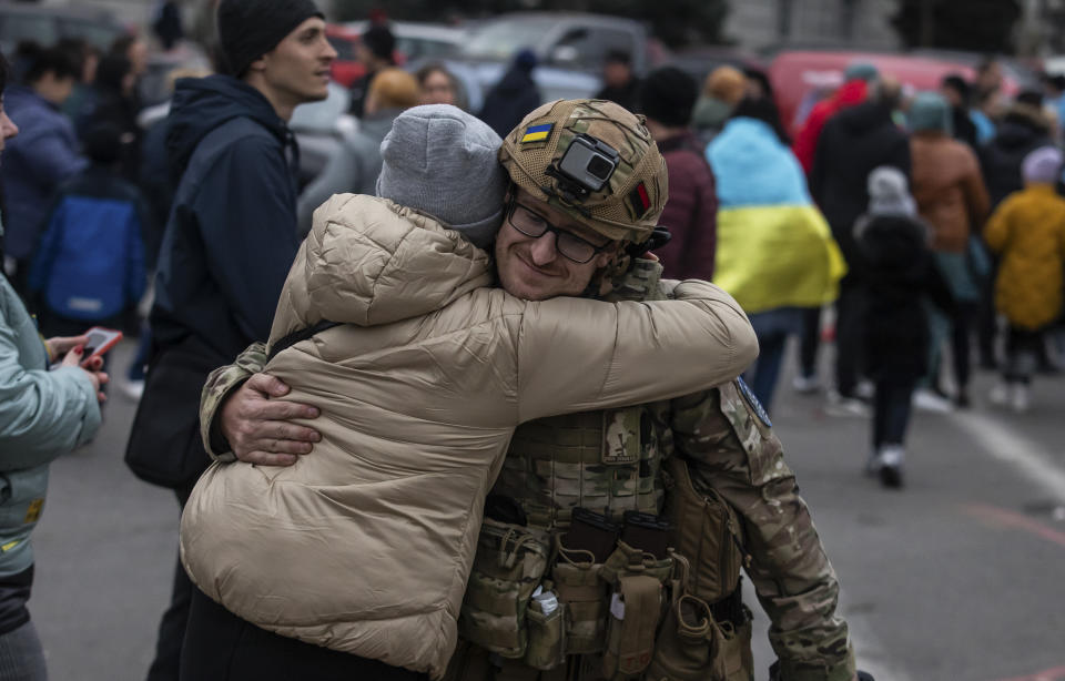 A woman hugs Ukrainian officer as they celebrate the recapturing Kherson, Ukraine, Saturday, Nov. 12, 2022. People across Ukraine awoke from a night of jubilant celebrating after the Kremlin announced its troops had withdrawn to the other side of the Dnieper River from Kherson. The Ukrainian military said it was overseeing "stabilization measures" around the city to make sure it was safe. (AP Photo/Yevhenii Zavhorodnii)