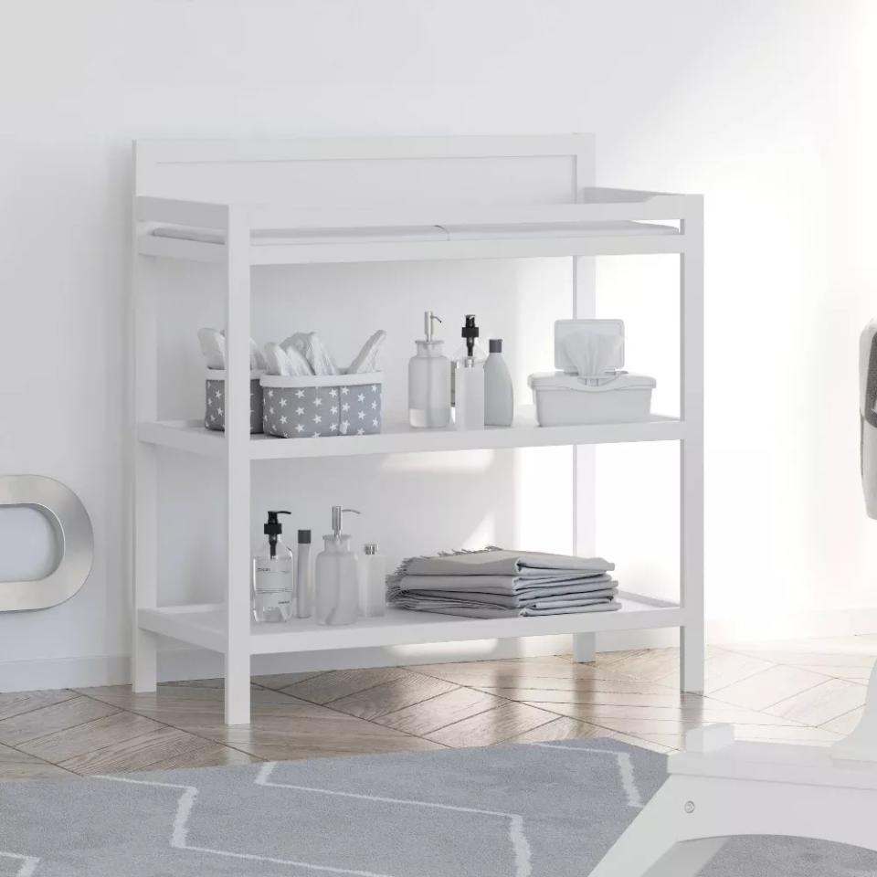 white changing table being used in a bathroom