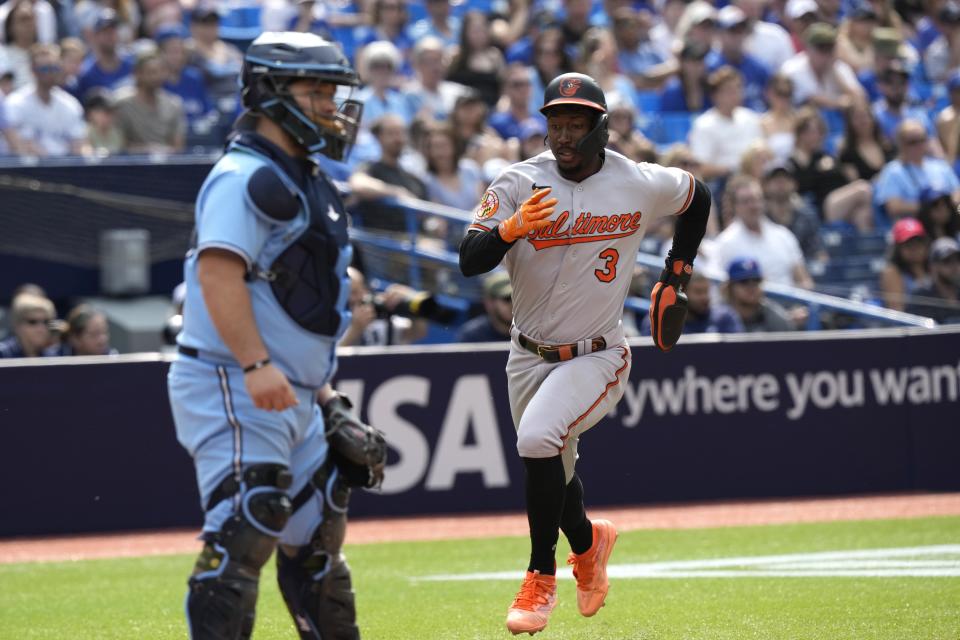 Baltimore Orioles shortstop Jorge Mateo (3) runs home with the go-ahead run as Toronto Blue Jays catcher Alejandro Kirk waits for a throw during the tenth inning of a baseball game in Toronto, Sunday, May 21, 2023. (Frank Gunn/The Canadian Press via AP)