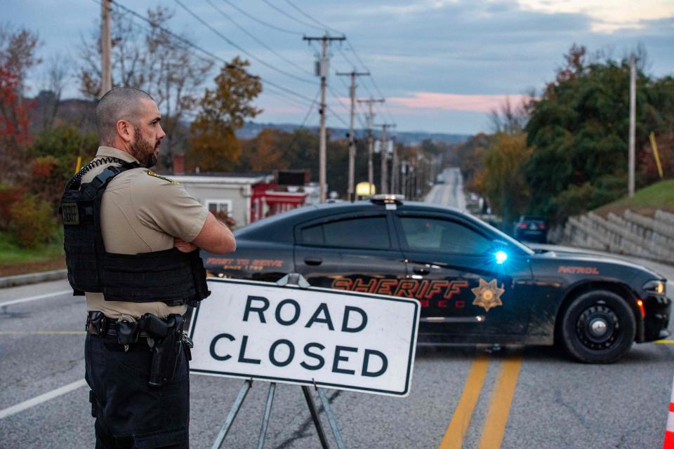 A police presence can be seen Thursday at Schemengees Bar where a mass shooting occurred Wednesday in Lewiston, Maine. A massive manhunt was underway for a gunman who a local official said killed at least 18 people and wounded dozens more.