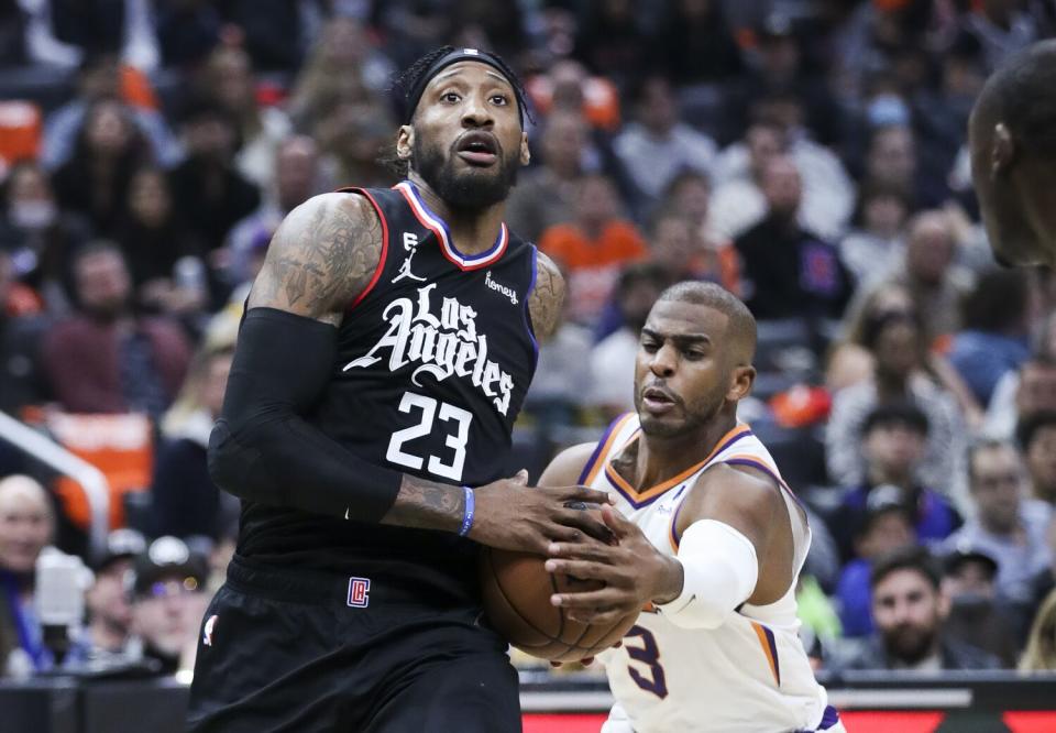 Suns guard Chris Paul, right, races for the ball as Clippers forward Robert Covington heads for the basket.