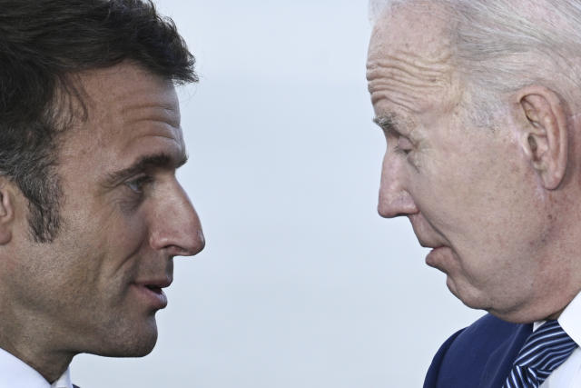 France's President Emmanuel Macron, left, speaks with U.S. President Joe Biden during a family photo of leaders of the G7 and invited countries during the G7 Leaders' Summit in Hiroshima, western Japan, Saturday, May 20, 2023. (Brendan Smialowski/Pool Photo via AP)