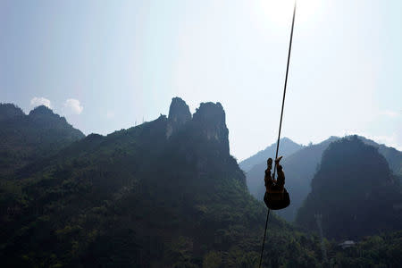 A Lisu man leaves his village on a zipline in Nujiang Lisu Autonomous Prefecture in Yunnan province, China, March 25, 2018. Picture taken March 25, 2018. REUTERS/Aly Song