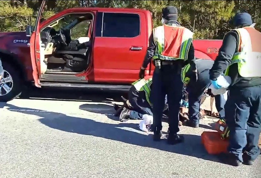 In this still from a video of the aftermath, medics tend to a fatally wounded Jason Walker as he lies near the back tires of a Ford F-150 that was driven by an off-duty county sheriff's lieutenant who shot him. A 'black box' in the truck that records impacts, would not register if the vehicle hit a pedestrian, an expert said.