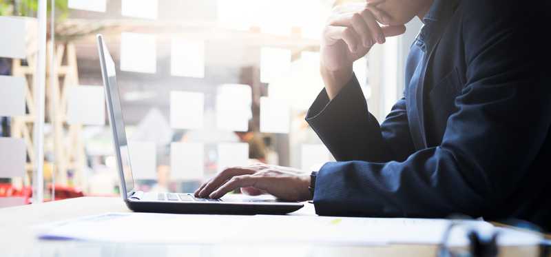 A businessman looking at his laptop screen.