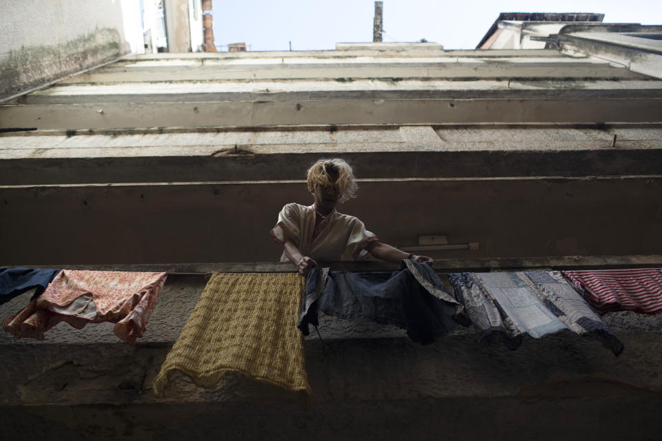 Transgender Alex hangs clothes out to dry at the squat known as Casa Nem in Rio de Janeiro, Brazil, Wednesday, July 8, 2020. In 2016, members of the LGBTQ community led by Indianara Siqueira took over the balconied building with small bedrooms, shared bathrooms and a big common kitchen. (AP Photo/Silvia Izquierdo)