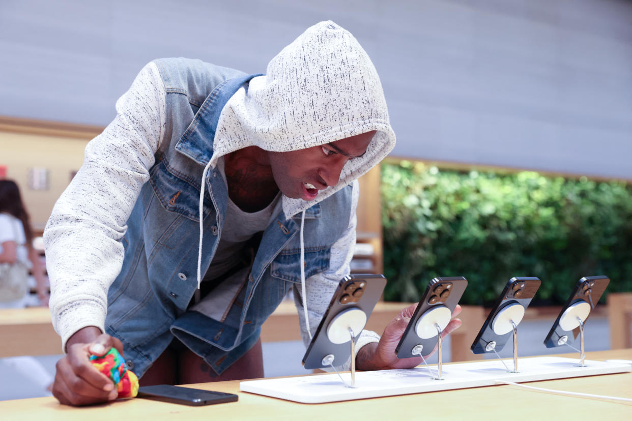 A customer looks at the Apple iPhone 14 range at the Apple Fifth Avenue store in Manhattan, New York City, U.S., September 16, 2022.  REUTERS/Andrew Kelly