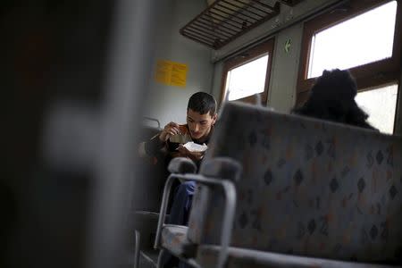 A passenger eats a meal as he travels on a train to Velingrad railway station, Bulgaria April 28, 2015. REUTERS/Stoyan Nenov