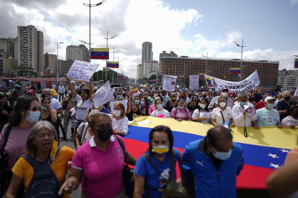 Trabajadores públicos activos y jubilados, incluidos maestros, protestan por mejores salarios y el resto de su bono de vacaciones que dicen fue pagado parcialmente, mientras marchan hacia el Ministerio de Trabajo en Caracas, Venezuela, el martes 2 de agosto de 2022. (Foto AP/Ariana Cubillos)