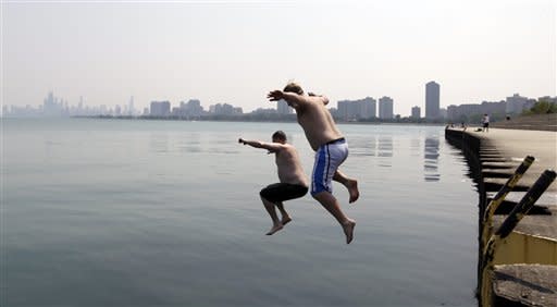 Jason Gerald, left, and Adam Hoffman jump into the Lake Michigan at Montrose Beach Thursday, June 28, 2012 in Chicago. The National Weather Service said the temperature Thursday hit 98 degrees. The last time it hit 100 was 2005. (AP Photo/ Nam Y. Huh)