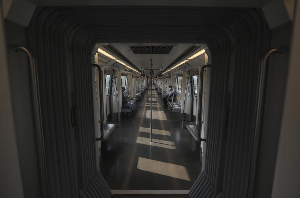 Commuters travel in an almost empty Delhi metro train in New Delhi, India, Monday, Sept. 7, 2020. India's coronavirus cases are now the second-highest in the world and only behind the United States, as the caseload crosses Brazil on a day when urban metro trains partially resume service in the capital New Delhi and other states. (AP Photo/Manish Swarup)