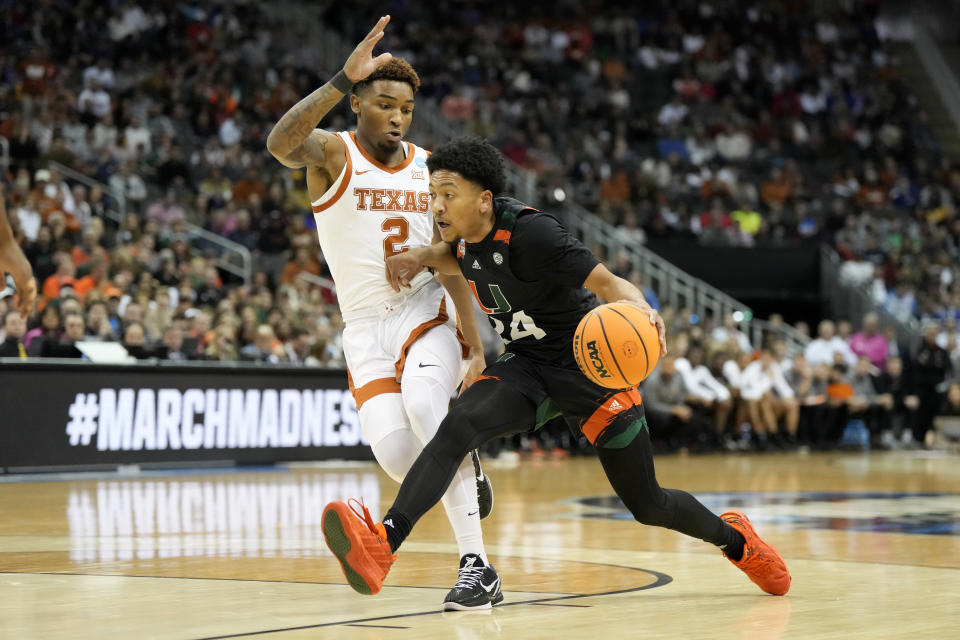 Miami guard Nijel Pack drives to the basket past Texas guard Arterio Morris in the first half of an Elite 8 college basketball game in the Midwest Regional of the NCAA Tournament Sunday, March 26, 2023, in Kansas City, Mo. (AP Photo/Jeff Roberson)