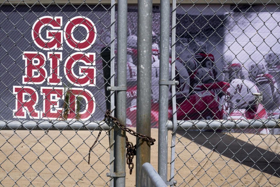 Gates leading into Memorial Stadium are padlocked, in Lincoln, Neb., Wednesday, Aug. 12, 2020. The Big Ten won't play football this fall because of concerns about COVID-19, becoming the first of college sports' power conferences to yield to the pandemic. The move was announced Tuesday. (AP Photo/Nati Harnik)