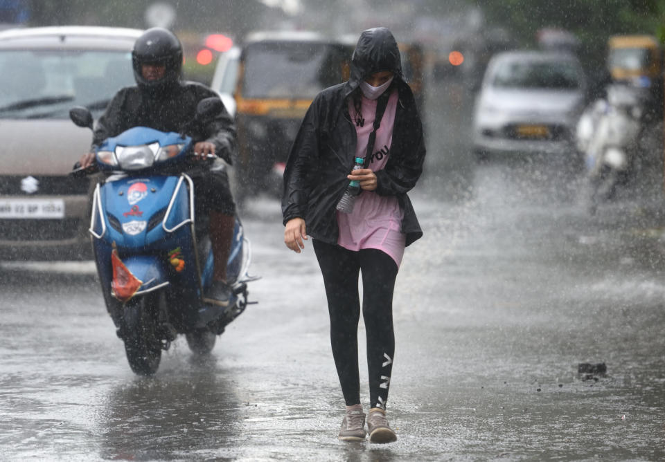 People deal with rain at Juhu, Mumbai. (Photo by Satish Bate/Hindustan Times via Getty Images)