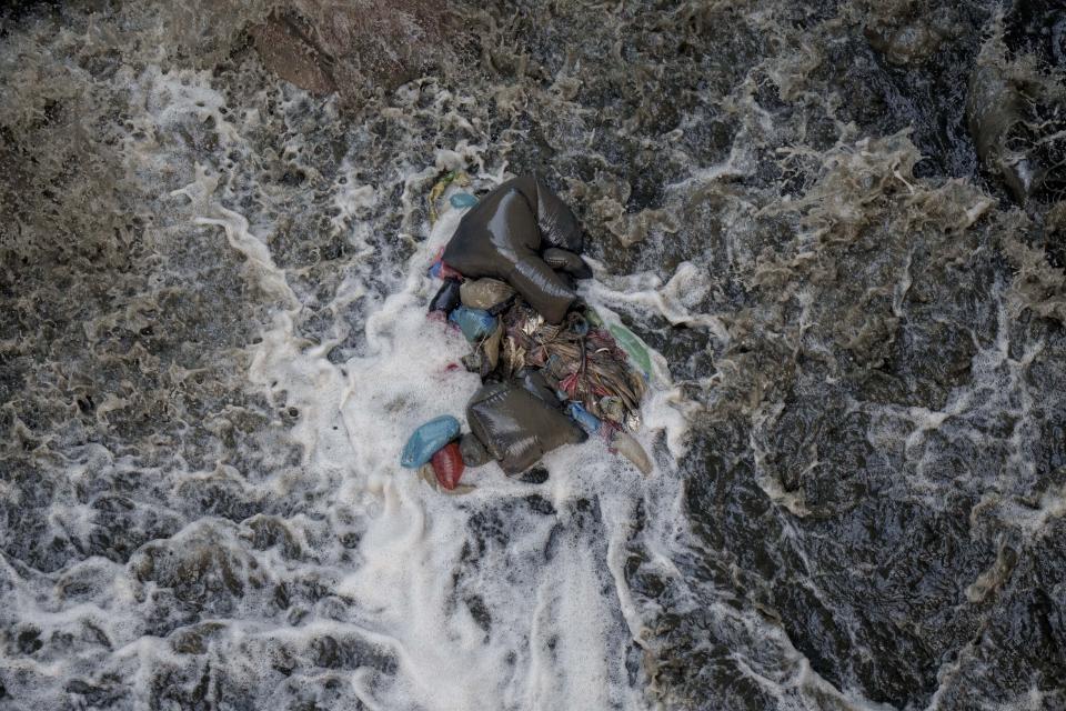 Trash sits in the Bagmati River as it flows in Kathmandu, Nepal, Tuesday, April 26, 2022. (AP Photo/Niranjan Shrestha)