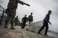 People from Morocco walk as Spanish Army deploy at the border of Morocco and Spain, at the Spanish enclave of Ceuta, on Tuesday, May 18, 2021. Ceuta, a Spanish city of 85,000 in northern Africa, faces a humanitarian crisis after thousands of Moroccans took advantage of relaxed border control in their country to swim or paddle in inflatable boats into European soil. Around 6,000 people had crossed by Tuesday morning since the first arrivals began in the early hours of Monday, including 1,500 who are presumed to be teenagers. (AP Photo/Javier Fergo)