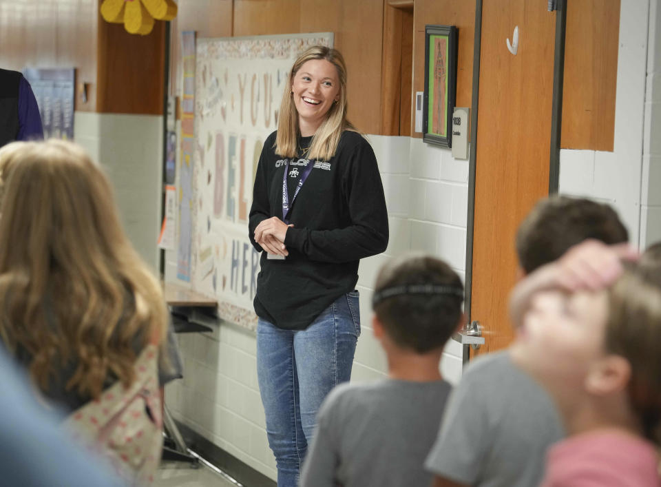 FILE - Ashley Joens, a student teacher and standout player on the Iowa State women's basketball team, laughs with fifth grade students as they make their way to the gymnasium for P.E. at Irving Elementary School in Indianola on Thursday, Aug. 18, 2022 in Des Moines, Iowa. Star women’s players like UConn’s Paige Bueckers and Iowa State’s Ashley Joens returned to college, where NIL deals and chartered travel offer more appeal than rookie salaries and commercial flights in the WNBA. (Bryon Houlgrave /The Des Moines Register via AP, File)