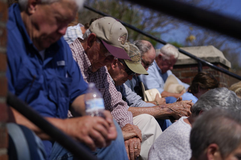 People sit and pray on the steps of the Rolling Fork United Methodist Church while worshiping, Sunday, March 26, 2023, in Rolling Fork, Miss. Emergency officials in Mississippi say several people have been killed by tornadoes that tore through the state on Friday night, destroying buildings and knocking out power as severe weather produced hail the size of golf balls moved through several southern states. (AP Photo/Julio Cortez)