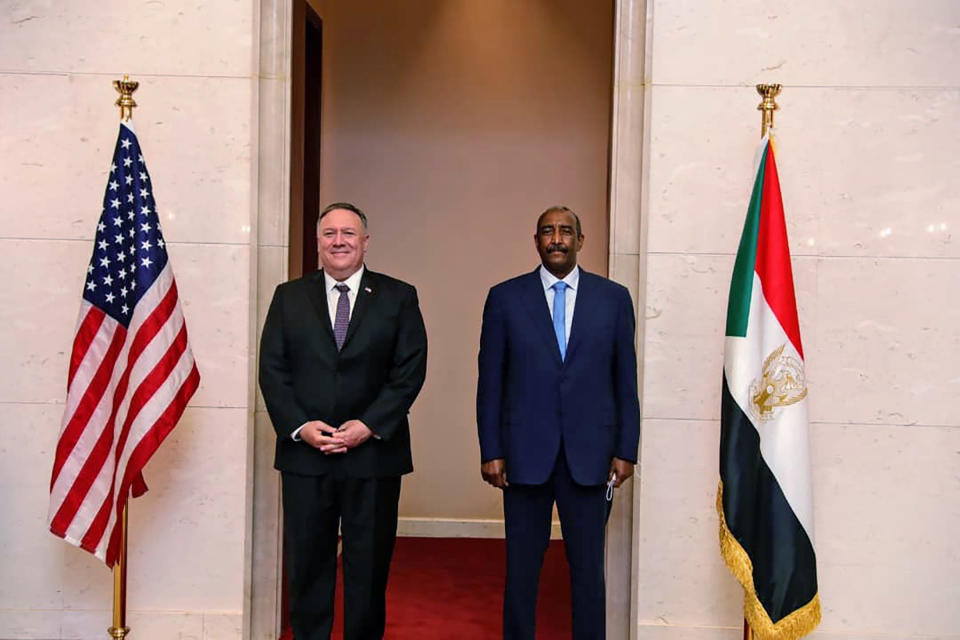 FILE - In this Aug. 25, 2020 file photo, U.S. Secretary of State Mike Pompeo stands with Sudanese Gen. Abdel-Fattah Burhan, the head of the ruling sovereign council, in Khartoum, Sudan. Officials in Sudan confirmed that a senior U.S.-Israeli delegation flew to Sudan on a private jet Wednesday, Oct. 21, 2020, and met with Burhan and others to wrap up a deal that would make Sudan the third Arab country to normalize ties with Israel this year. (Sudanese Cabinet via AP, File)