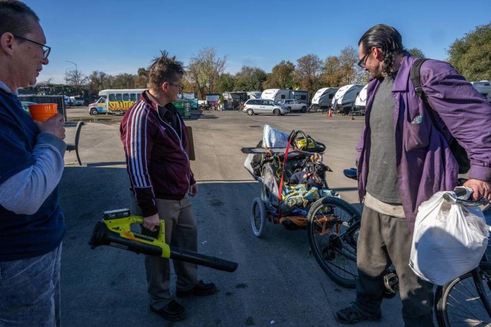 Sharon Jones, left, and Joyce Williams, co-founders of Camp Resolution, chat Wednesday with visitor Mathew Tekano, right, who was pulling his dog Nog Nog in a cart after visiting his girlfriend inside the camp. “There is no other place like this. Any other place looks like a hurricane or tornado – it’s in such disarray – and they still keep wanting to close them down,” Tekano said.