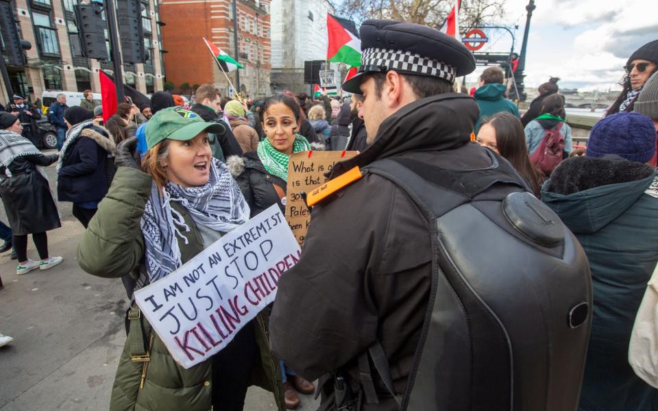 'I am not an extremist, just stop killing children' reads one woman's placard