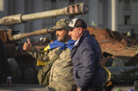 U.S. Sen. Mark Kelly, D-Ariz., and a Ukrainian soldier pose for a photo near displayed damaged Russian tanks in central Kyiv, Ukraine, Monday, Sept. 18, 2023. (AP Photo/Efrem Lukatsky)