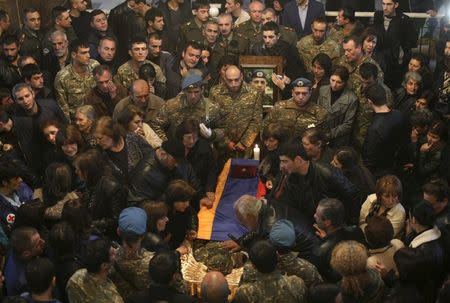 People surround a coffin with the body of an Armenian serviceman, who was killed in clashes over the breakaway Nagorno-Karabakh region according to Armenian officials, during a memorial service at a church in Yerevan, Armenia, April 4, 2016. REUTERS/Varo Rafayelyan/PAN Photo