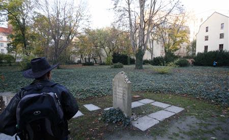 A visitor stands next to the gravestone of German philosopher Moses Mendelssohn at Grosse Hamburger Strasse Jewish cemetery in Berlin, October 31, 2013. REUTERS/Fabrizio Bensch