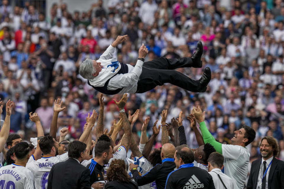 Jugadores del Real Madrid lanzan al técnico Carlo Ancelotti durante los festejos por el título tras la victoria ante el Espanyol en la liga el sábado 30 de abril del 2022 (AP Foto/Bernat Armangue)