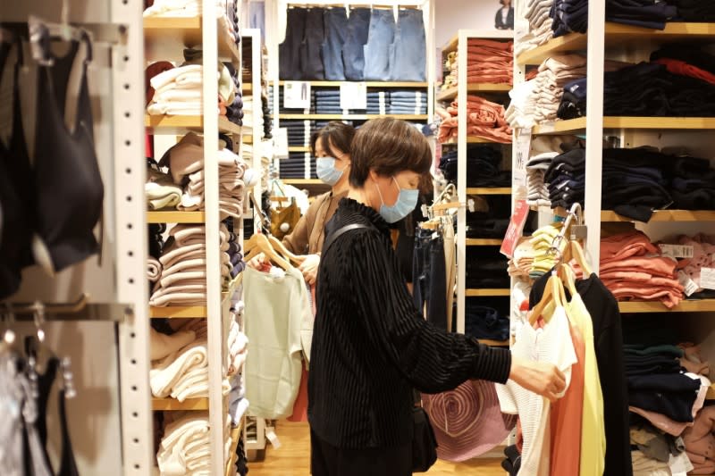 Women shop inside a store of the Fast Retailing's fashion chain Uniqlo, in Beijing