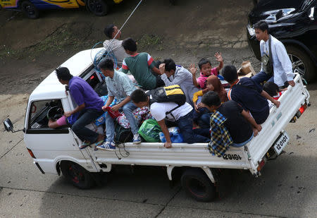 Residents who stayed at evacuation centers, due to the assault of government troops against pro-Islamic State militant groups, ride in a van with their belongings after they were allowed to return to their homes at Basak, Malutlut district in Marawi city, southern Philippines October 29, 2017. REUTERS/Romeo Ranoco