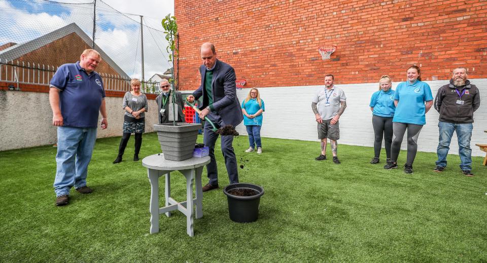 Britain's Prince William, Duke of Cambridge (C) plants a tree in a pot during his visit to Brighter Futures, a consortium of eight local groups which encourage loal people to participate in community activities, in Rhyl, Denbighshire, Wales on May 6, 2021. (Photo by Peter Byrne / POOL / AFP) (Photo by PETER BYRNE/POOL/AFP via Getty Images)