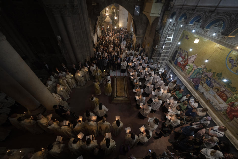 Clergymen walk in a procession around the Stone of Unction, the stone slab traditionally claimed as the stone where Jesus' body was prepared for burial during the Easter Sunday Mass led by Latin Patriarch of Jerusalem Pierbattista Pizzaballa, at the Church of the Holy Sepulchre, in the Old City of Jerusalem, Sunday, March 31, 2024, where many Christians believe Jesus Christ was crucified, buried and rose from the dead. (AP Photo/Leo Correa)