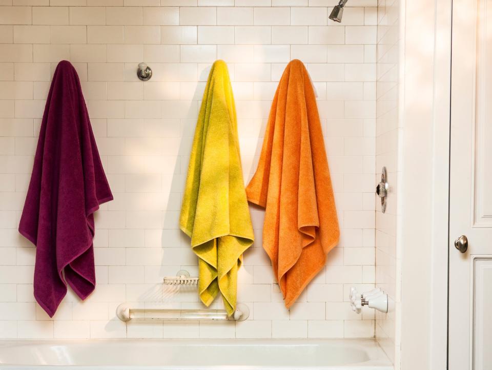 Purple, yellow, and orange towels in bathroom