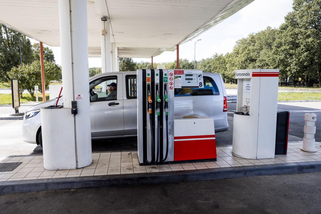 Rental van stopped at a petrol station while on holiday in France. There is a man sitting in the drivers seat.