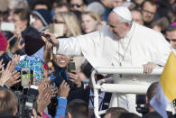 Pope Francis caresses a child as he arrives to celebrate a Mass in Freedom Square, in Tallinn, Estonia, Tuesday, Sept. 25, 2018. Pope Francis concludes his four-day tour of the Baltics visiting Estonia. (AP Photo/Mindaugas Kulbis)