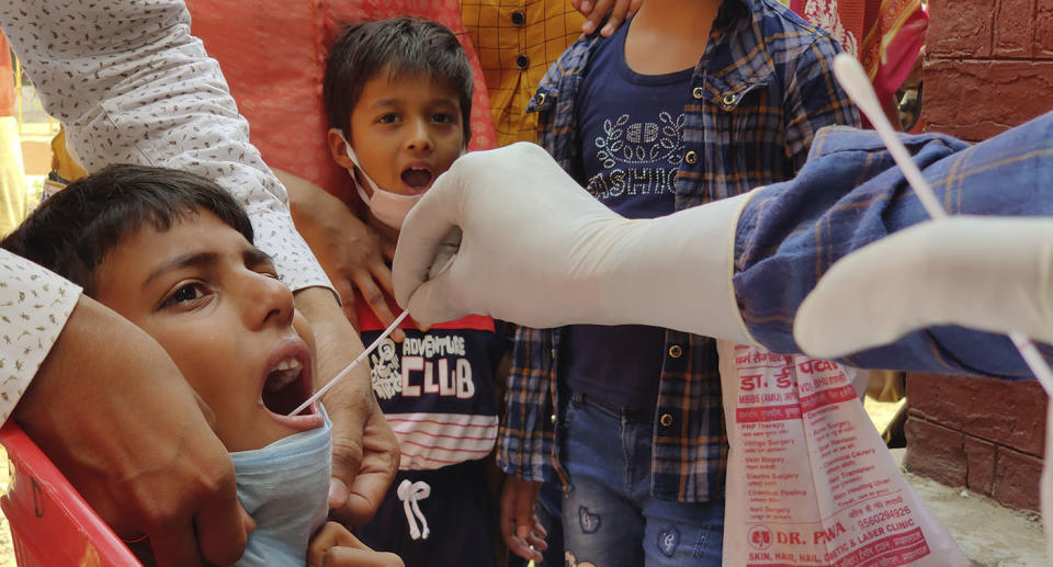 A child is swabbed for a Covid test in India.