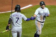 Colorado Rockies' Garrett Hampson, right, returns to the dugout after scoring on a single by Ryan McMahon off Pittsburgh Pirates relief pitcher Chris Stratton during the eighth inning of a baseball game in Pittsburgh, Tuesday, May 24, 2022. At left is Brendan Rodgers. (AP Photo/Gene J. Puskar)