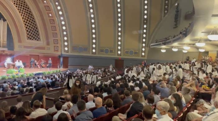 medical students in a theater stand up and walk out