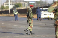 Armed soldiers patrol a street in Harare, Friday, July, 31, 2020. Zimbabwe's capital, Harare, was deserted Friday, as security agents vigorously enforced the country's lockdown amidst planned protests.Police and soldiers manned checkpoints and ordered people seeking to get into the city for work and other chores to return home. (AP Photo/Tsvangirayi Mukwazhi)