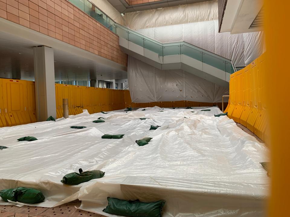 A white tarp covers the floor of an indoor building.