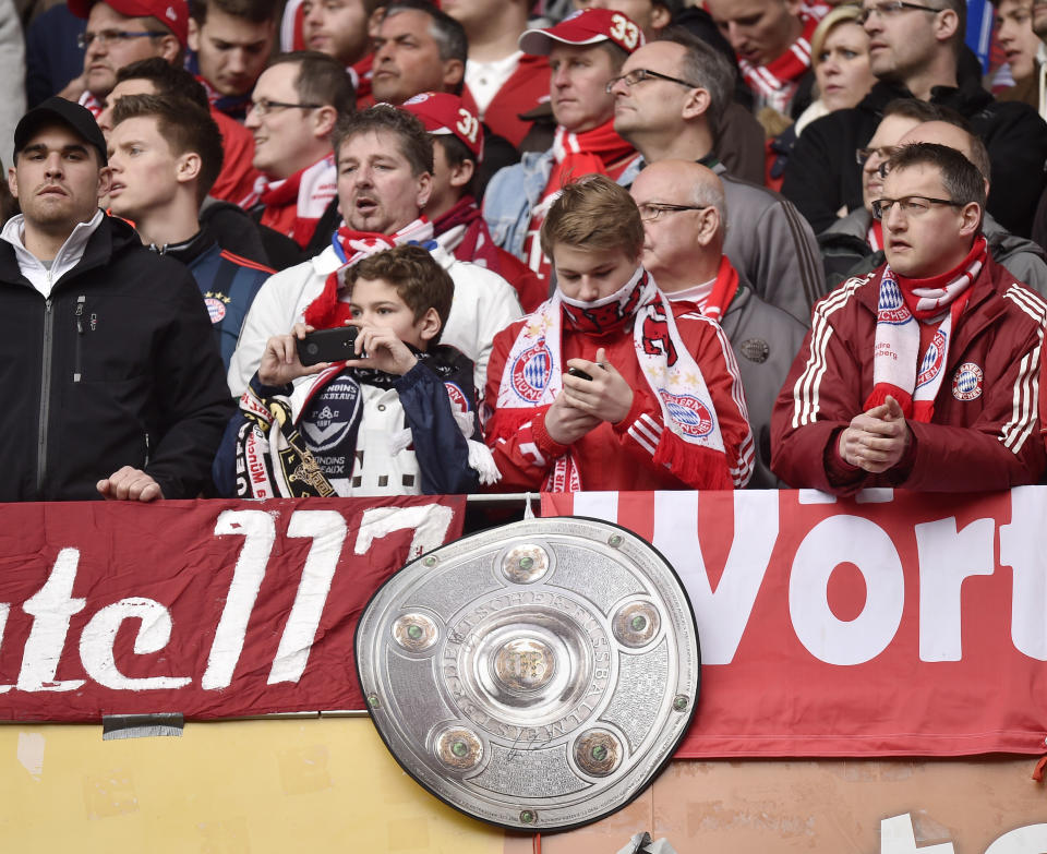 Bayern fans with a trophy wait during the German Bundesliga soccer match between FSV Mainz 05 and Bayern Munich in Mainz, Germany, Saturday, March 22, 2014. (AP Photo/Martin Meissner)