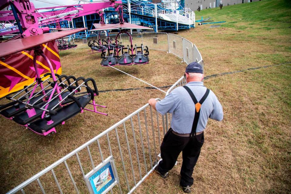 A supervisor with the NC Department of Labor uses a tape measure to make sure guard rails are the proper distance from a ride Tuesday, Oct. 12, 2021 at the NC State Fair in Raleigh.