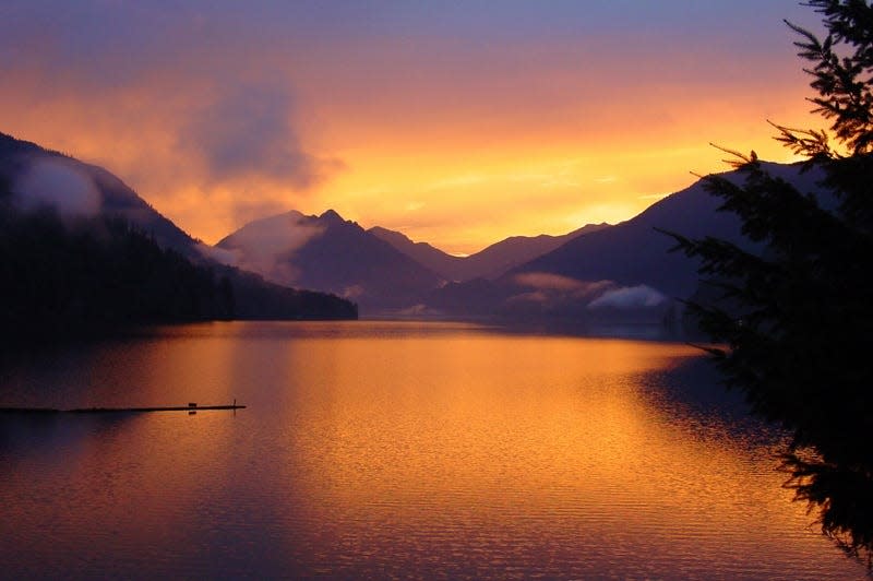 Sunrise paints the sky above Lake Crescent at Olympic National Park.